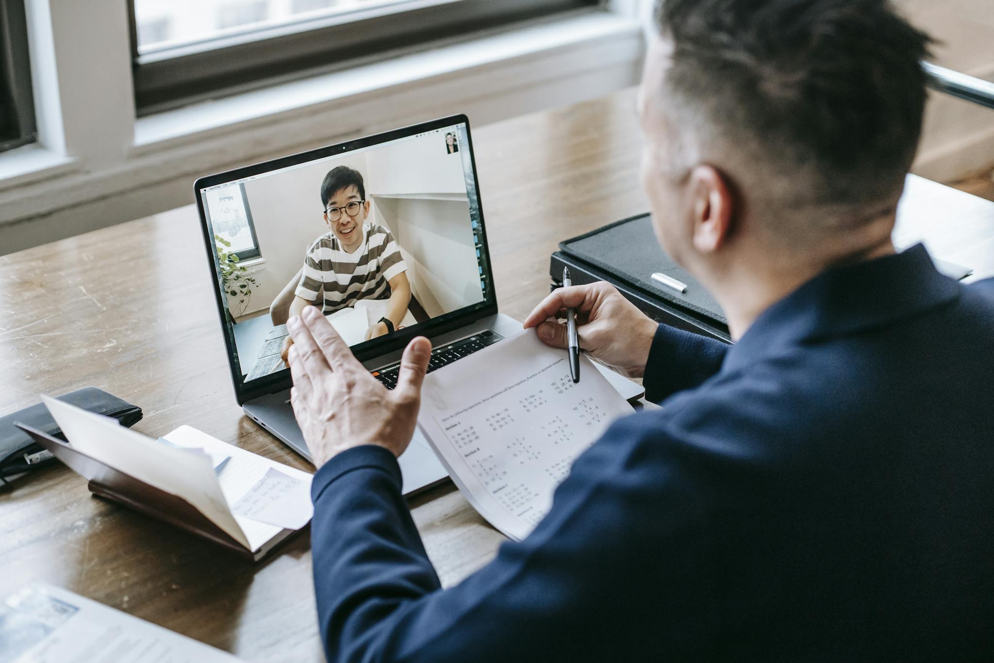 Home 13 A professional having a video conference on a laptop from a home office, engaging in online communication.